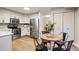 Modern kitchen with stainless steel appliances, white cabinets, and adjacent dining area for convenient meals at 7114 S Acoma Way, Littleton, CO 80120