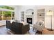 Sunlit living room with a fireplace, built-in shelves, large windows, and modern furnishings at 7114 S Acoma Way, Littleton, CO 80120