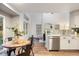 Open floor plan integrates dining area, kitchen, and living room with wood flooring and natural light at 7114 S Acoma Way, Littleton, CO 80120