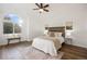 Spacious bedroom with large window, ceiling fan, wood floors, and elegant decor at 7114 S Acoma Way, Littleton, CO 80120