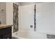 Bright white bathtub with white tile and accent stripe at 8174 Dudley Cir, Arvada, CO 80005