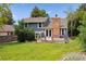 Charming two-story home with a large deck, brick chimney and lush greenery, perfect for outdoor living at 8174 Dudley Cir, Arvada, CO 80005
