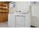 Washer and Dryer with shelving near the basement window at 8174 Dudley Cir, Arvada, CO 80005