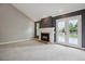 Bright living room featuring a fireplace, neutral walls, and french doors to a wooden deck at 8174 Dudley Cir, Arvada, CO 80005