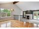 Spacious living room with hardwood floors, a fireplace, and large windows, creating a warm ambiance at 8174 Dudley Cir, Arvada, CO 80005