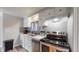 Well-lit kitchen features white cabinets, stainless steel appliances, and gray subway tile backsplash at 9021 Rampart St, Federal Heights, CO 80260