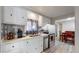 Bright kitchen with stainless steel appliances, white cabinetry, and view to the adjacent dining area at 9021 Rampart St, Federal Heights, CO 80260