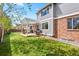 A well-maintained backyard showing the gray-paneled home, an expansive lawn, and patio with pergola at 134 S Pontiac St, Denver, CO 80230