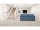 Finished basement with carpet, stairs, and a comfortable blue sofa with TV at 134 S Pontiac St, Denver, CO 80230