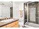 Well-lit bathroom featuring a glass enclosed shower, attractive vanity, and neutral colored tiling at 134 S Pontiac St, Denver, CO 80230