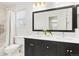 Well-lit bathroom featuring a double vanity with a large framed mirror and a tub with shower at 134 S Pontiac St, Denver, CO 80230
