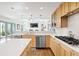 Open kitchen features stone countertops, stainless steel appliances, and ample cabinet space at 134 S Pontiac St, Denver, CO 80230