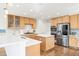 Modern kitchen boasts stainless steel appliances, wood cabinets, and an island with counter seating at 134 S Pontiac St, Denver, CO 80230