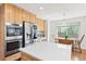 Bright kitchen with stainless appliances, large island and breakfast nook with backyard view at 134 S Pontiac St, Denver, CO 80230