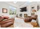 Bright living room has a skylight, large windows, fireplace, and comfortable leather seating at 134 S Pontiac St, Denver, CO 80230