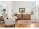 A light and airy living room featuring hardwood floors, a high ceiling, and elegant furnishings at 134 S Pontiac St, Denver, CO 80230