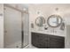 Modern bathroom boasts dual vanities, decorative mirrors, and a glass-enclosed shower at 10252 E 58Th Ave, Denver, CO 80238