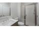 Bright bathroom featuring a glass shower enclosure, white tiled walls, modern vanity and faucet at 10252 E 58Th Ave, Denver, CO 80238