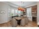 Bright dining area with unique copper pendant lighting and a charming brick wall at 10252 E 58Th Ave, Denver, CO 80238
