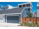 View of the detached garage with a blue door and backyard fence in a modern planned community at 10252 E 58Th Ave, Denver, CO 80238