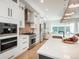 Bright kitchen showcasing premium appliances, white cabinetry, and a view to the living area at 10252 E 58Th Ave, Denver, CO 80238