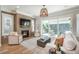 Bright living room features brick fireplace, oversized windows and light wood flooring at 10252 E 58Th Ave, Denver, CO 80238