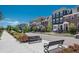Charming street featuring colorful townhomes, sidewalks and landscaping with benches for relaxing at 10252 E 58Th Ave, Denver, CO 80238