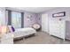 Spacious bedroom with lavender walls, a twin bed, and a large dresser at 944 Black Saddle St, Elizabeth, CO 80107