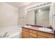 Bathroom featuring a soaking tub, double vanity, and updated lighting fixtures providing a relaxing and functional space at 11862 W Stanford Pl, Morrison, CO 80465