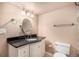 Bathroom featuring vanity with sink, black countertop, white cabinets, a toilet and mirror at 11862 W Stanford Pl, Morrison, CO 80465