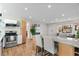Open floor plan showing the kitchen island with bar stools and stainless steel appliances at 3256 S Glencoe St, Denver, CO 80222