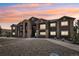 Modern apartment building with stone accents and a well-maintained parking area at sunset at 875 E 78Th Ave # 72, Denver, CO 80229