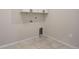 A clean laundry room offering tile floors, overhead cabinets, and washer/dryer hookups at 875 E 78Th Ave # 72, Denver, CO 80229