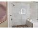 Modern walk-in shower with stone pebble floor, seating, and white subway tile surround at 2100 16Th St # 600, Denver, CO 80202
