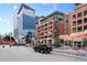 Exterior view of modern brick apartments, pedestrian bridge, and street with restaurants at 2100 16Th St # 600, Denver, CO 80202