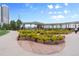 Pedestrian walking path encircles a vibrant green space with decorative flowering bushes and shaded seating areas at 2100 16Th St # 600, Denver, CO 80202