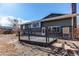 Backyard of home with wooden deck, brick facade, and mature trees under a blue sky at 1698 S Kingston St, Aurora, CO 80012