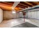 Unfinished basement with concrete walls, open beams, and carpeted flooring and storage at 1698 S Kingston St, Aurora, CO 80012