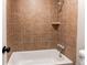 Full bathroom featuring tile surround in the bath tub with shower head and tile shelf and matching tile flooring at 1698 S Kingston St, Aurora, CO 80012
