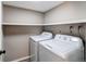 Functional laundry room with modern washer and dryer, storage shelf, and neutral decor at 1698 S Kingston St, Aurora, CO 80012