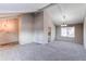 An expansive living room offers tall ceilings, carpet flooring and lots of natural light in a neutral color palette at 1698 S Kingston St, Aurora, CO 80012
