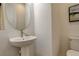 Small bathroom with a modern pedestal sink and a round mirror at 16550 Umatilla Pl, Broomfield, CO 80023