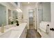 Modern bathroom with double vanity, glass shower, and neutral tile flooring at 16550 Umatilla Pl, Broomfield, CO 80023