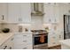Close up of a bright kitchen with white cabinets, stainless steel appliances, and quartz countertops at 16550 Umatilla Pl, Broomfield, CO 80023