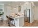 Bright kitchen features white cabinets, stainless steel appliances, and a large quartz island with seating at 16550 Umatilla Pl, Broomfield, CO 80023