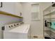 Well-lit laundry room with white cabinets and modern washer and dryer at 16550 Umatilla Pl, Broomfield, CO 80023