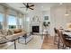 Sun-filled living room with fireplace, large windows, modern furnishings, and hardwood floors at 16550 Umatilla Pl, Broomfield, CO 80023