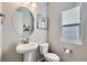 Bathroom with pedestal sink, oval mirror, decorative art, and natural light at 623 S Pitkin Ct, Aurora, CO 80017
