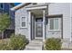 Stylish front entry featuring a modern door, stone accents, and manicured landscaping at 623 S Pitkin Ct, Aurora, CO 80017