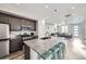Modern kitchen with a large granite island, stainless steel appliances, and open floor plan at 623 S Pitkin Ct, Aurora, CO 80017